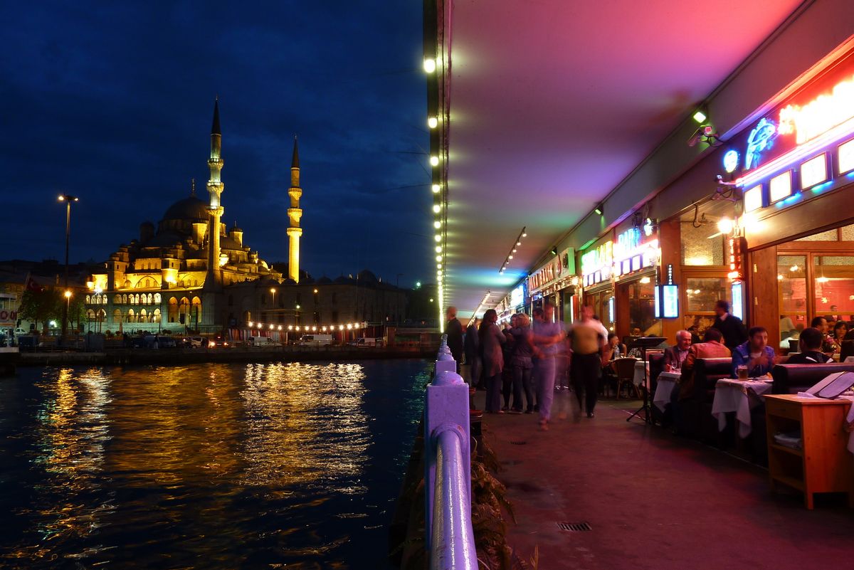 Aan de ene kant de Gelatabrug met restaurants en vissers bovenop de brug, aan de andere kant een moskee in de verte.