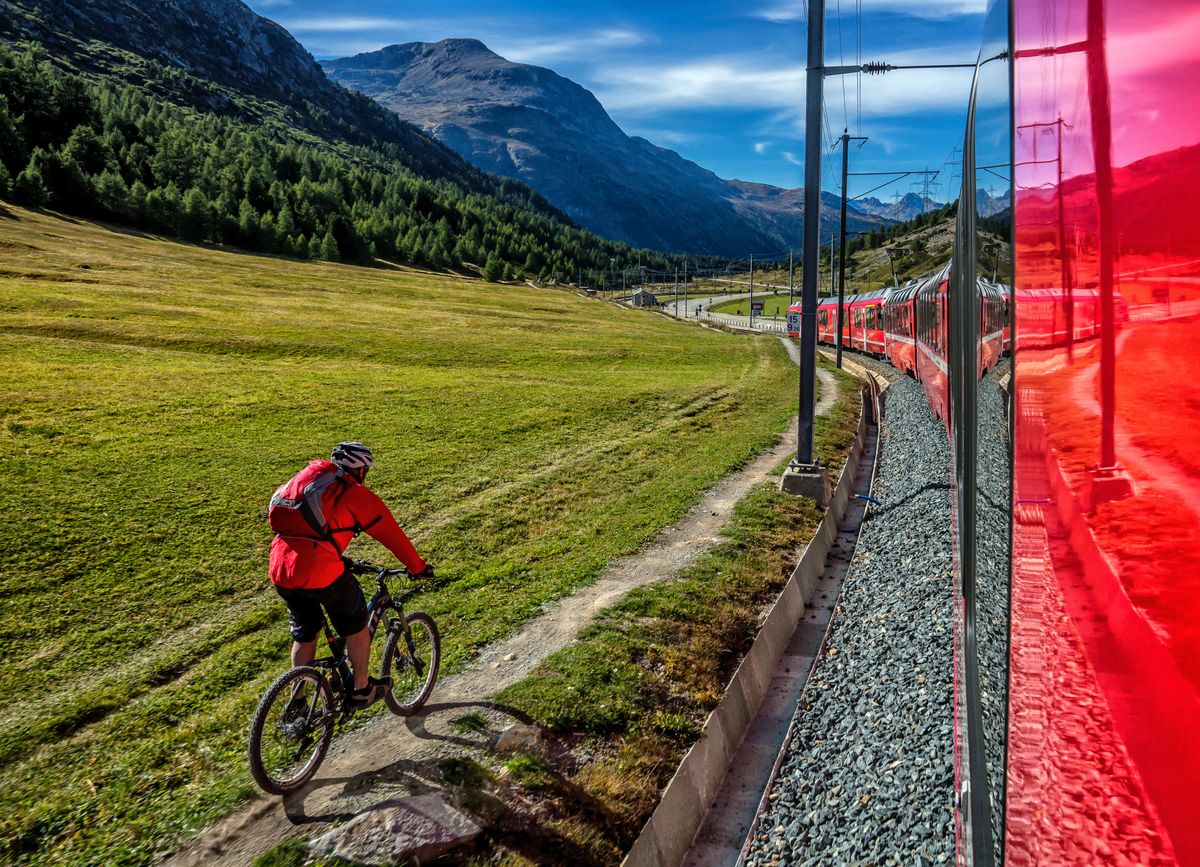 CYCLIST KEEPS PACE WITH THE EXPRESS, THROUGH THE GLORIOUS SWISS ALPS